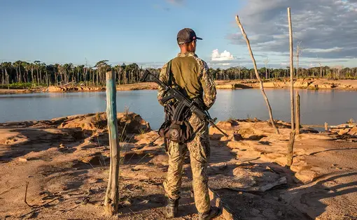 A soldier patrols La Pampa, an area in Peru that was once lush rainforest. Image by Brett Gundlock. Peru, 2019.