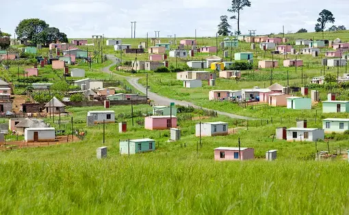 A village of brightly colored Mandela Houses in Zulu Village, Zululand, South Africa. Image by Joseph Sohm / Shutterstock. South Africa, 2019.