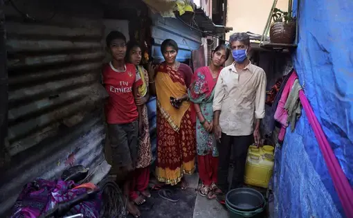 Mina Ramesh Jakhawadiya, center, poses for a picture with her family members outside her one room house in a slum in Mumbai. Image by AP Photo/Rajesh Kumar Singh. India, 2020.