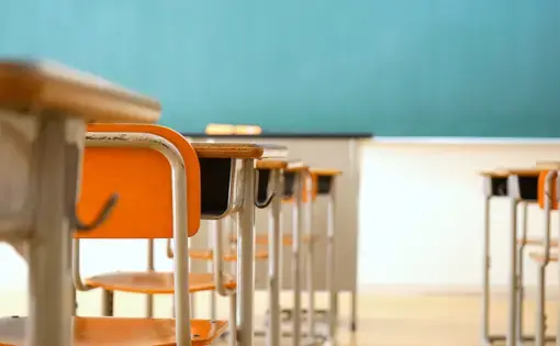 Empty desks and blackboard in a classroom. Image by maroke / Shutterstock.com. Japan, undated.