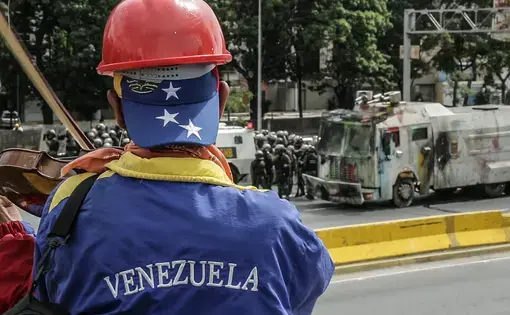 A violinist plays in front of Venezuelan National Guard during an anti-government protest in Caracas. Image by Bruno Federico. Venezuela, 2017.