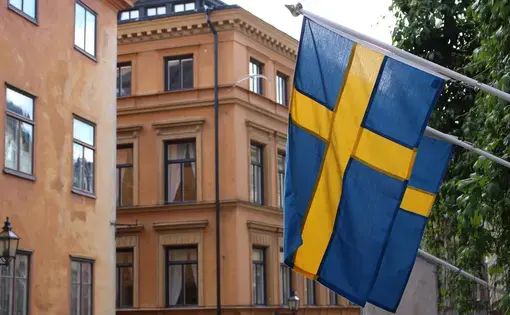 A Swedish flag aloft in Stockholm. Image by Amy Russo. Sweden, 2017.