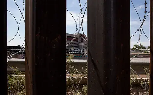 Razor wire supplements the border fence in El Paso, Texas on Aug. 23, 2019. Image by Jinitzail Hernández/CQ Roll Call. United States, 2019.