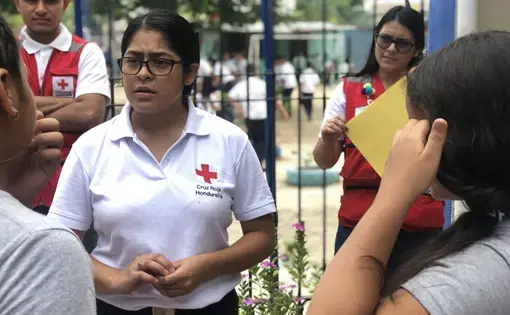 The Honduran Red Cross helps kids affected by migration. Here, Karen Martinez talks with a student. Image by Jaime Joyce. Honduras, 2019. 
