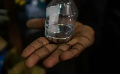 A miner shows mercury used in the extraction of gold at a mine. Image by Bram Ebus. Guyana, undated.