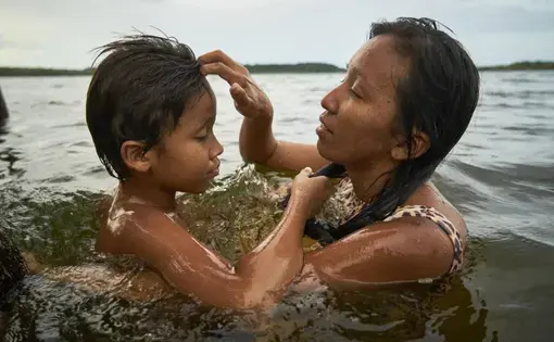 Tupí takes a bath with her 10-year-old son. Image by Pablo Albarenga. Brazil, 2019.