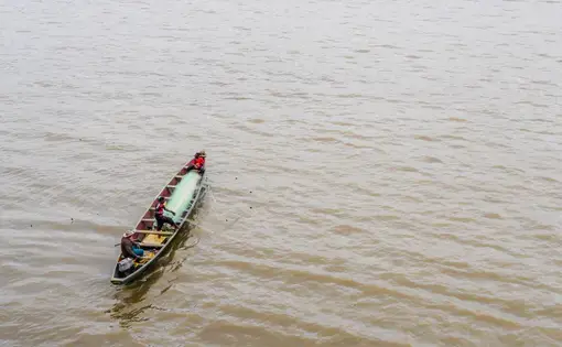 A man and his son fishing with a pirogue in the Wouri river, near the port of Douala. Image by Sidoine Mbogni/Shutterstock. Cameroon, 2019.