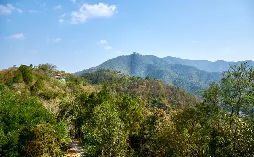 Verdant valley with hills in the distance and clear blue sky