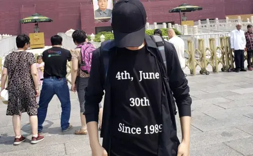 man stands in black shirt that reads 4th June 30th since 1989 in front of forbidden city