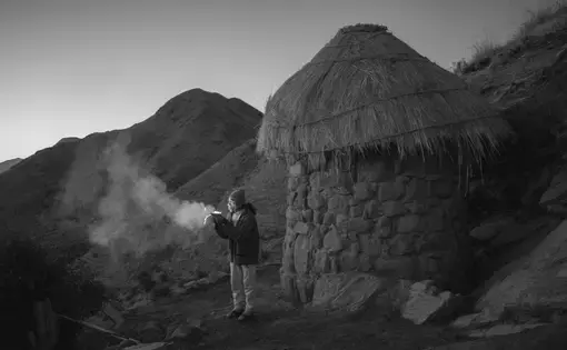 Man burning outside hut