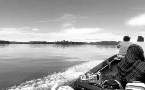 Three people are sitting on a boat.