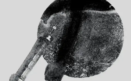 Black and white artwork showing a syringe and an arm overlaying a dark circle.