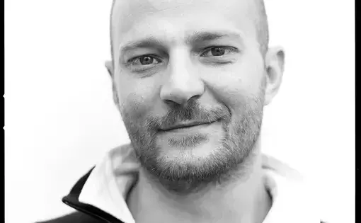A man with a polo shirt smiles.