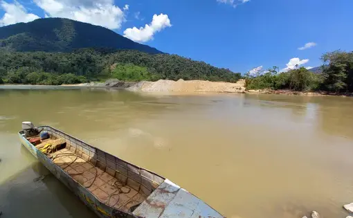 A boat floats in a shallow river.