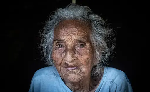 An old woman poses for the camera.