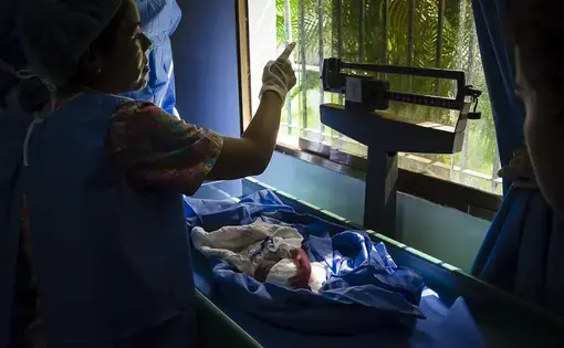 A woman holds the baby