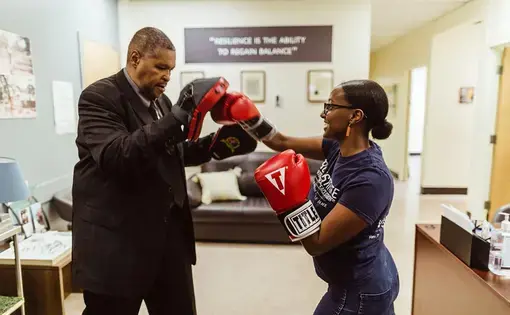 Gregory Banks—a torture survivor and CTJC Learning Fellow—boxes with a former intern, Helina Haile. Banks and Haile worked on launching a community healing boxing program at the Chicago Torture Justice Center. Image courtesy of Ez Powers. United States, undated.