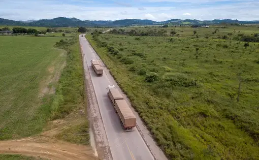 Two trucks carry soy across the BR-163 highway in Brazil.