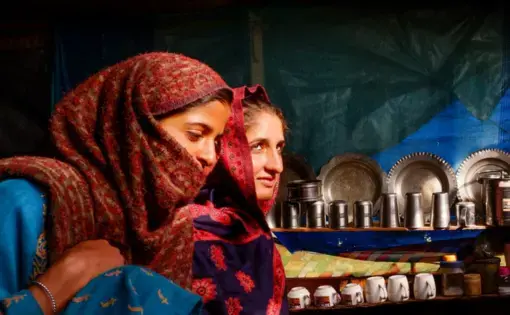 two young women sit in their tent