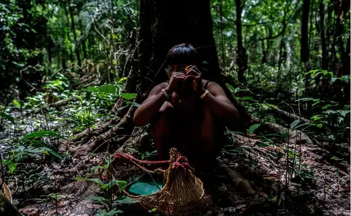 Priscila eats a buriti seed she just collected during a Dzomori.