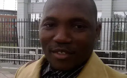 A man wears a brown jacket with a brown shirt.