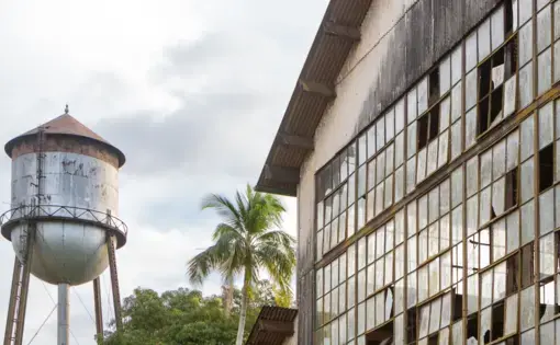 A water tower is right next to a warehouse in Brazil.