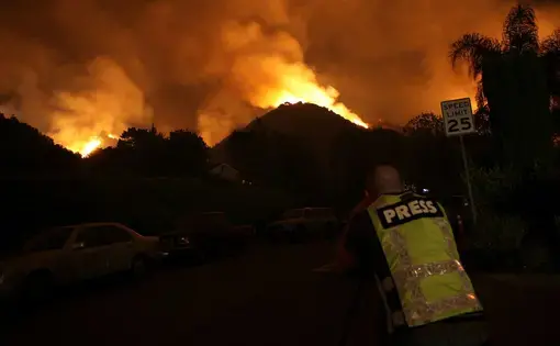 a man from the press looks at a fire