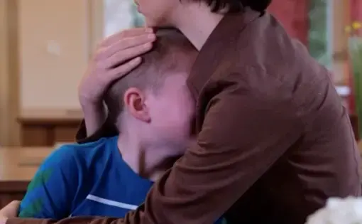 a woman holds a distressed child