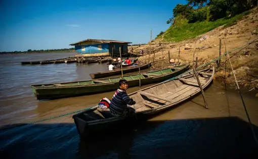 a woman stands in a boat and stares