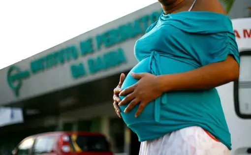 A pregnant person holds their swollen womb