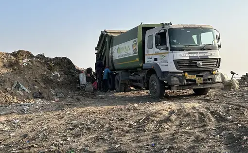 Unloading a garbage truck into a landfill