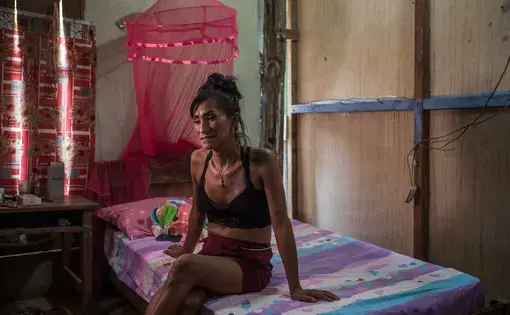 a woman sits on her bed, Peru