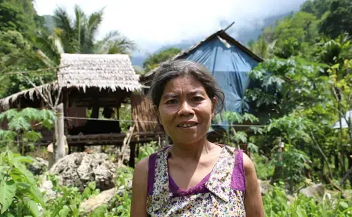 A mid-shot of an old woman in purple top.