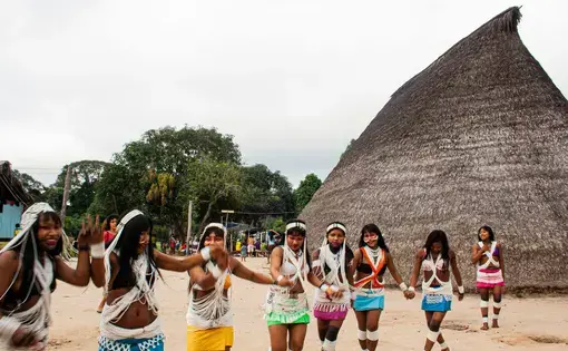 Indigenous girls dance happily in their colourful, traditional attires.