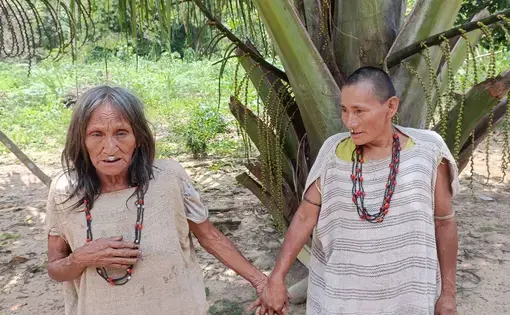 A grandmother and mother stand hand in hand.