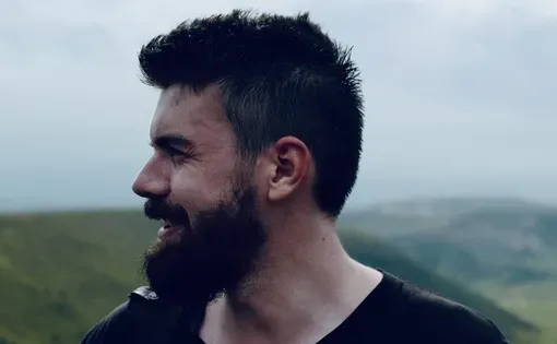 Side profile of Hugh against a mountainous background