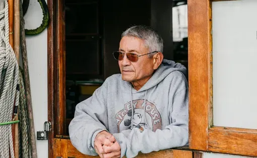 a crab boat captain looks out the window on his boat