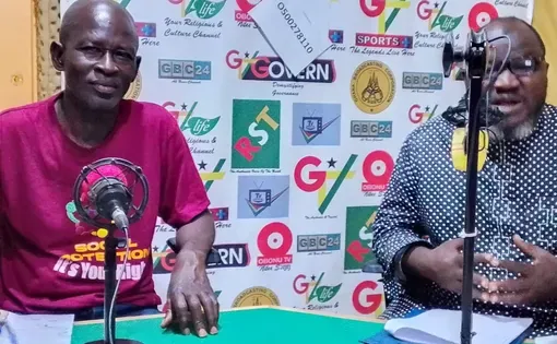 two men sit to host a radio show with microphones