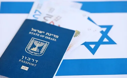 Israeli passport and currency laid over the Israeli national flag