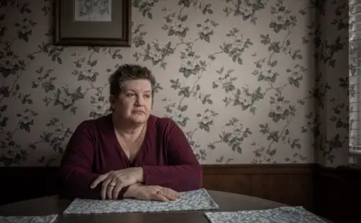 Amy Slagle sits in her kitchen in south Tulsa. Slagle’s daughter Clorinda Archuleta is serving three concurrent life sentences for permitting child abuse and child neglect. “She never shouldn’t be there. She doesn’t belong there,” says Slagle, who believes her daughter’s sentence was excessive. Image by Shane Brown. United States, 2020.