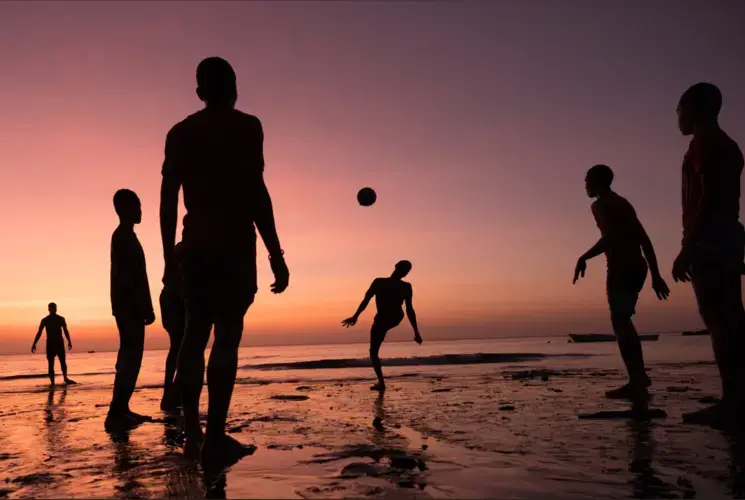 Youths playing soccer on an Anjouan beach all said they planned to leave the Comoros for the nearby French island of Mayotte. Image by Tommy Trenchard for The New York Times. Comoros, 2019.