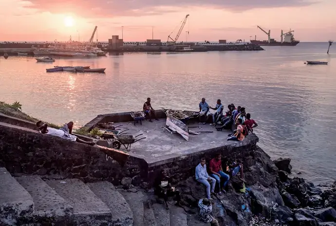 Comorians resting on the waterfront in Moroni, the capital of the Union of the Comoros. Image by Tommy Trenchard. Comoros, 2019.