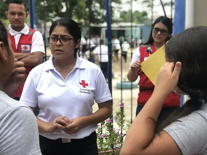 The Honduran Red Cross helps kids affected by migration. Here, Karen Martinez talks with a student. Image by Jaime Joyce. Honduras, 2019.&nbsp;