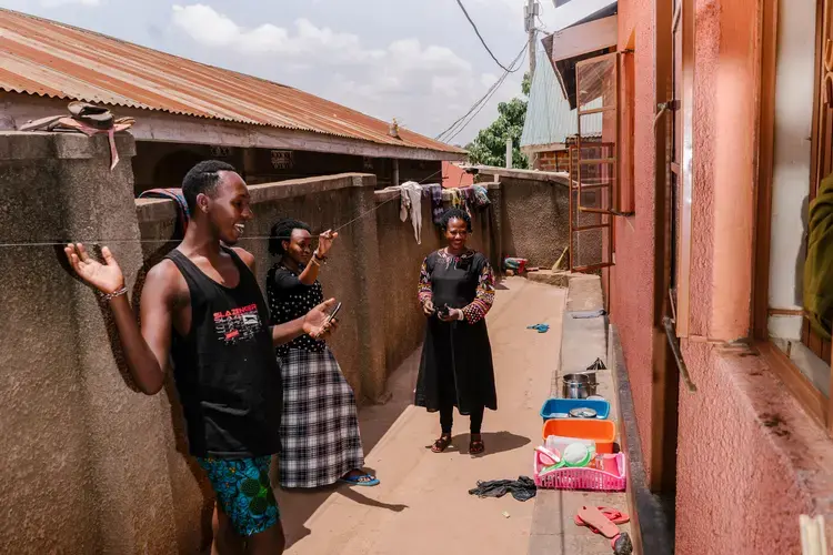 Javan outside the family's home, with her mother and cousin.&nbsp;Image by Jake Naughton. Uganda, 2017.