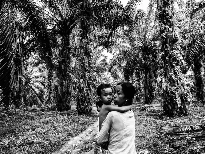 Ida and her children Santi and Fitri climb the hill home after visiting their village’s only source of water, a muddy reservoir. Image by Xyza Cruz Bacani. Indonesia, 2018.