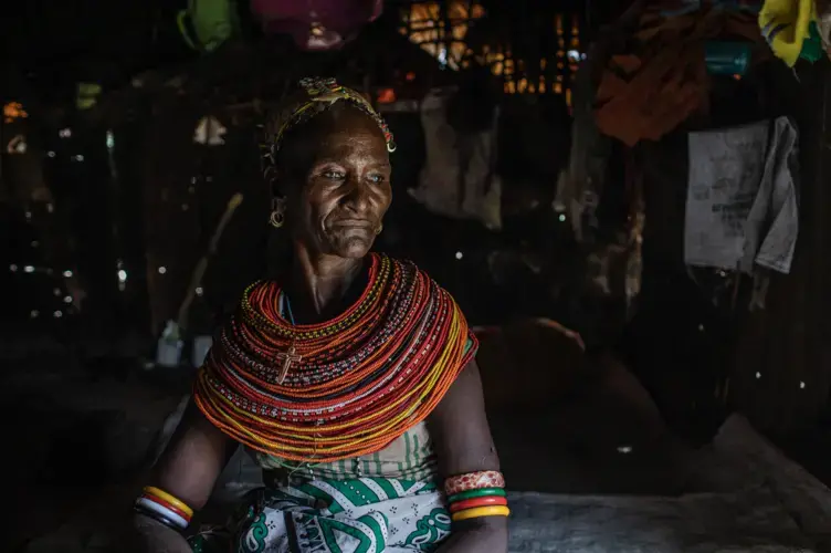 Christine Lemowonapi, a former Rendille circumciser, sits inside her home in Merille, Kenya. She has lost her source of income since the government outlawed the practice.&nbsp;Image by Will Swanson. Kenya, 2020.