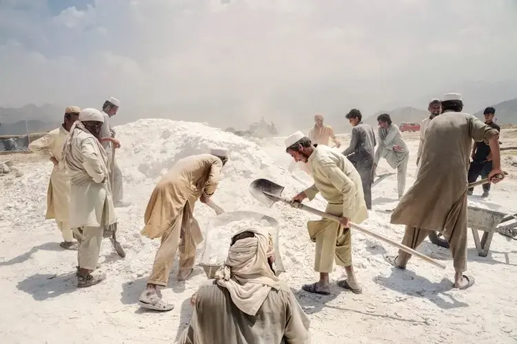 Workers shovelling talc, on Afghanistan’s eastern border. Most Afghan talc is exported to Pakistan, and much of it goes on to the West. The Taliban reportedly generate millions of dollars a year by taxing producers. isis hopes to seize control of the talc mines. Image by Adam Ferguson. Afghanistan, 2019.