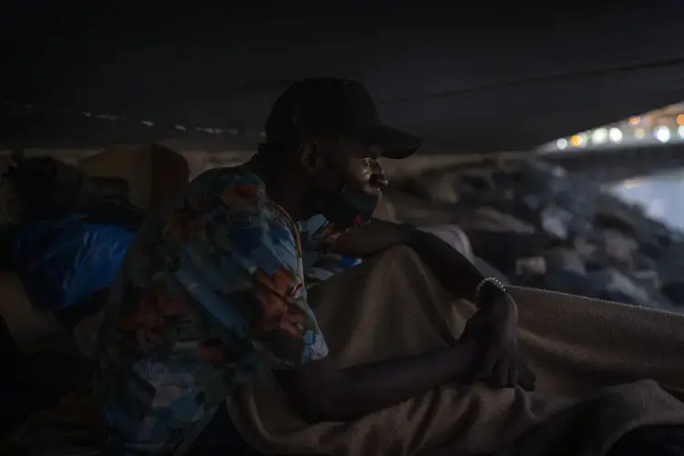 Khalid, a migrant from Gambia, sits on a breakwater under a bridge in Gran Canaria island, Spain, on Saturday, Aug. 22, 2020.&nbsp;Image by Emilio Morenatti/AP Photo. Spain, 2020.