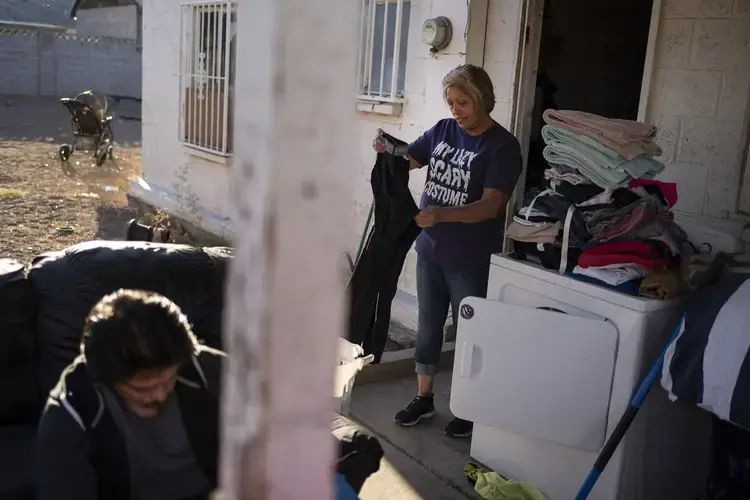 Norma Flores, 54, folds the laundry while her son works on his bicycle at their home in Henderson, Nev., Tuesday, Nov. 10, 2020.&nbsp;Image by Wong Maye-E / AP Photo. United States, 2020.