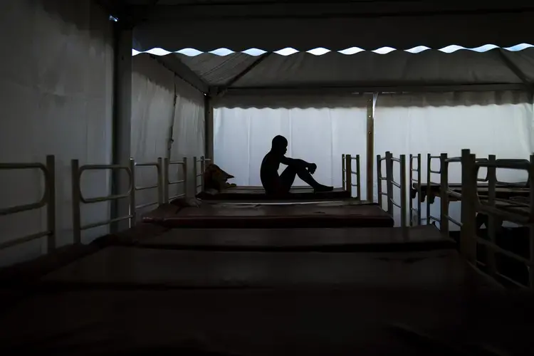 Mamadou Patherazi, from Guinea, sits on a bunk bed of the Modern Christian Mission Church in Fuerteventura, one of the Canary Islands, Spain, on Saturday, Aug. 22, 2020.&nbsp;Image by Emilio Morenatti/AP Photo. Spain, 2020.